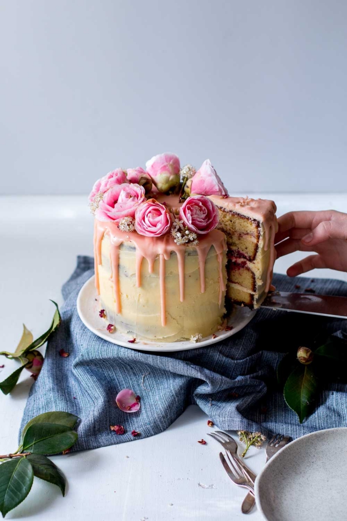 joli gâteau d'anniversaire aux amandes et aux framboises, parfumé au citron, avec un coulis de chocolat blanc coloré rose et un nappage gâteau à la crème au beurre et au fromage frais