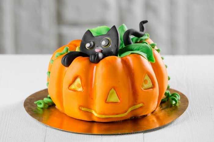recette d halloween effrayante, modèle de gâteau citrouille réalisé avec fondant coloré en orange et petites figurines en sucre