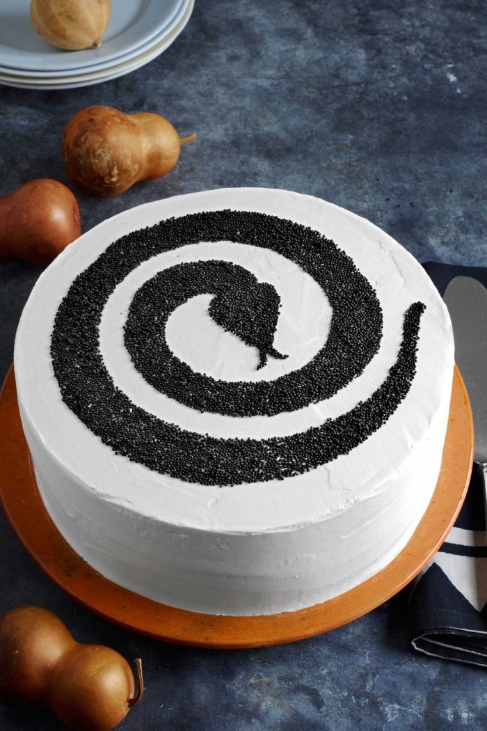 idée repas halloween ou dessert facile de dernière minute, modèle de gâteau à glaçage blanc avec déco en sucre noir design serpent