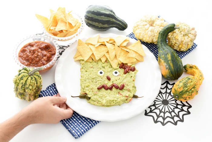 une présentation amusante d'un guacamole frankenstein d'halloween, servi avec des chips tortilla