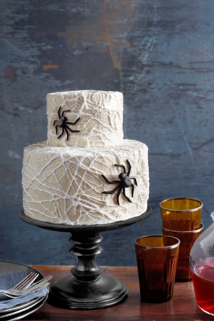 modèle de gâteau sur deux étages au glaçage blanc avec décoration en chocolat blanc design toile d'araignée, recette gateau halloween