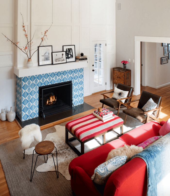 manteau cheminée en carrelage bleu et blanc type credence en mosaique dans salon avec murs blancs et décoration scandinave sur sol parquet