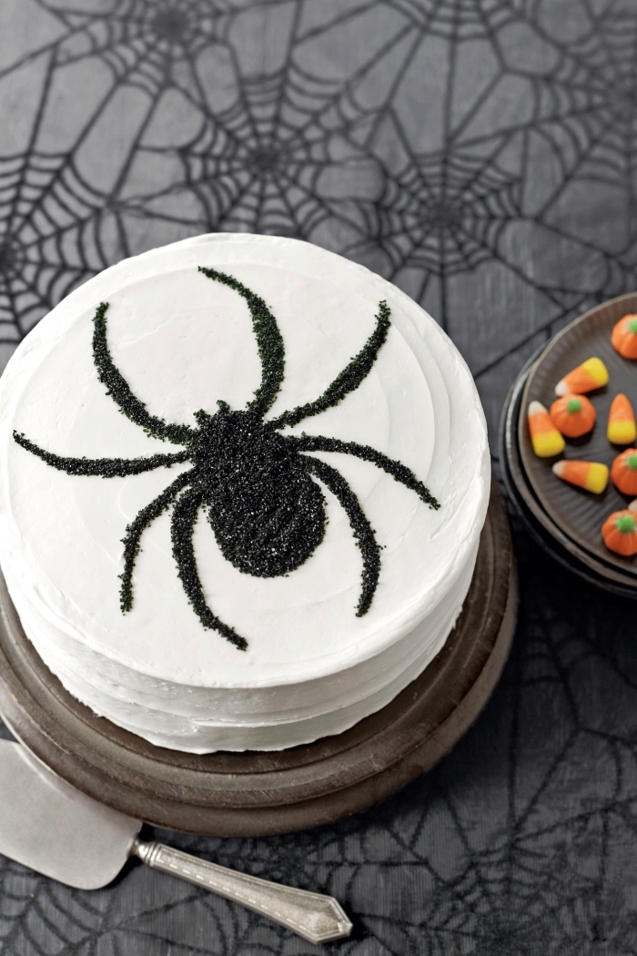 modèle de gateau araignée stylé au glaçage à vanille avec jolie décoration élégante à design insecte en sucre noir