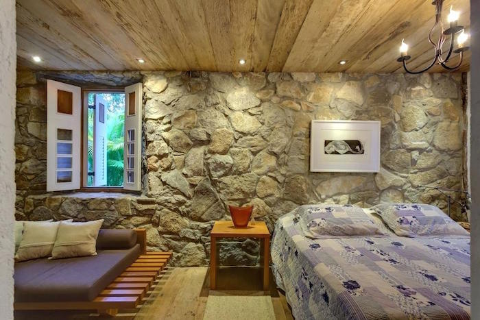 chambre rénovée avec mur intérieur en pierre et plafond en bois pour déco rustique