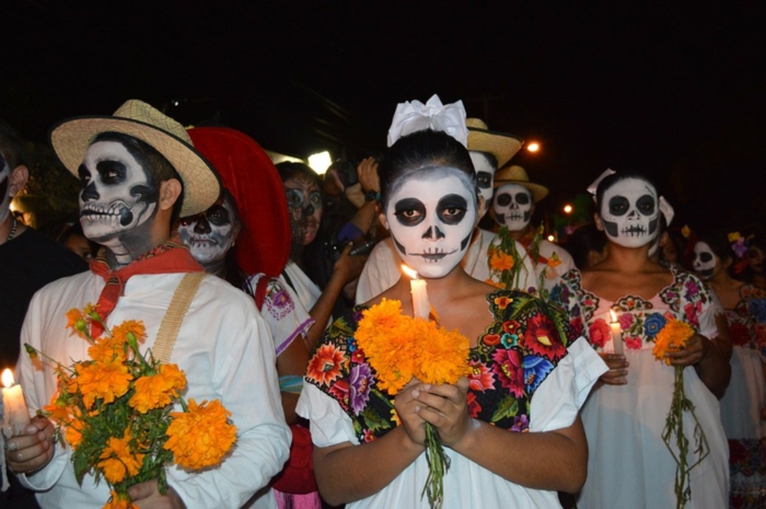 la fête des morts en Mexique, mexicains habillés pour la fête, bouquets jaunes, bougies allumées et maquillage tete de mort