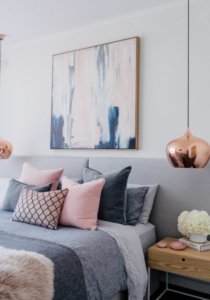 deco cocooning, coussins en rose et gris, tableau abstrait, deux lampe pendante finition cuivrée, chevet en bois