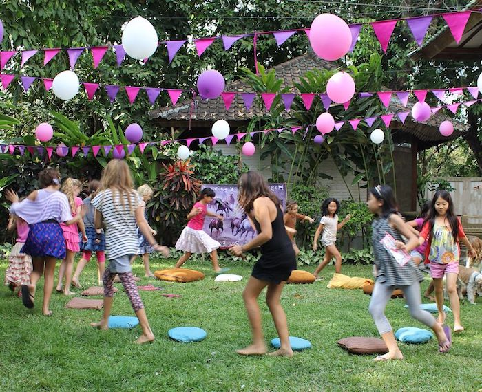 le coussin musical sur un gazon à l extérieur avec des enfants, decoration anniversaire guirlande à fanions et ballons colorés, anniversaire 9 ans