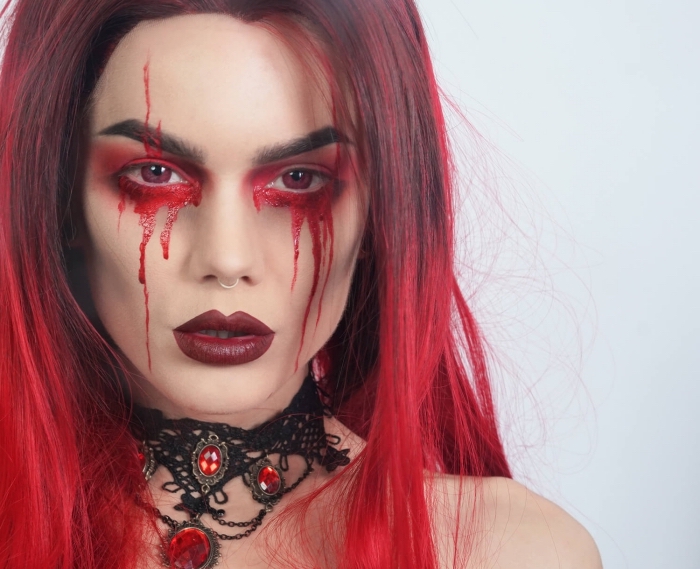 un maquillage demon gothique avec des larmes de sang et du rouge à lèvres bordeaux, maquillage effet halo rouge
