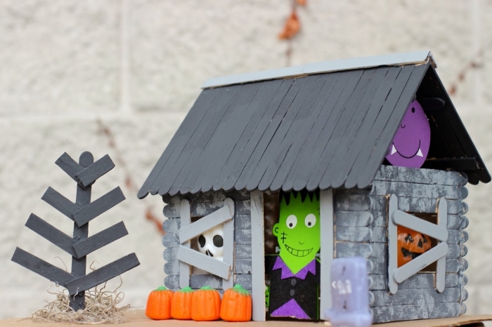 bricolage halloween maternelle avec des bâtonnets de glace en bois, fabrication d'une maison hantée avec des bâtonnets de glace et des personnages d'halloween découpés en carton