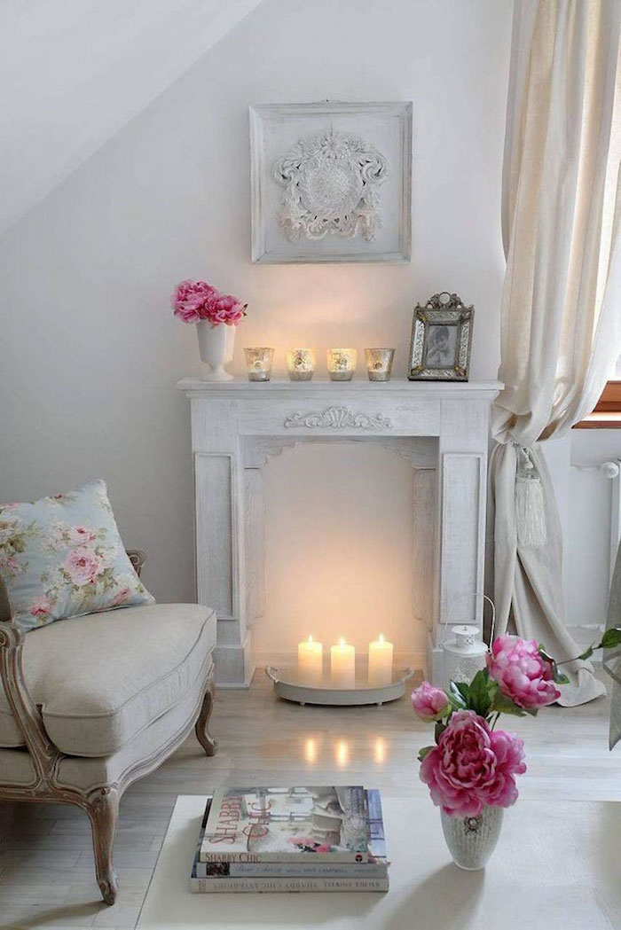 déco de salon classique romantique avec manteau de cheminée en bois blanc patine avec bougies dans foyer et vases de roses