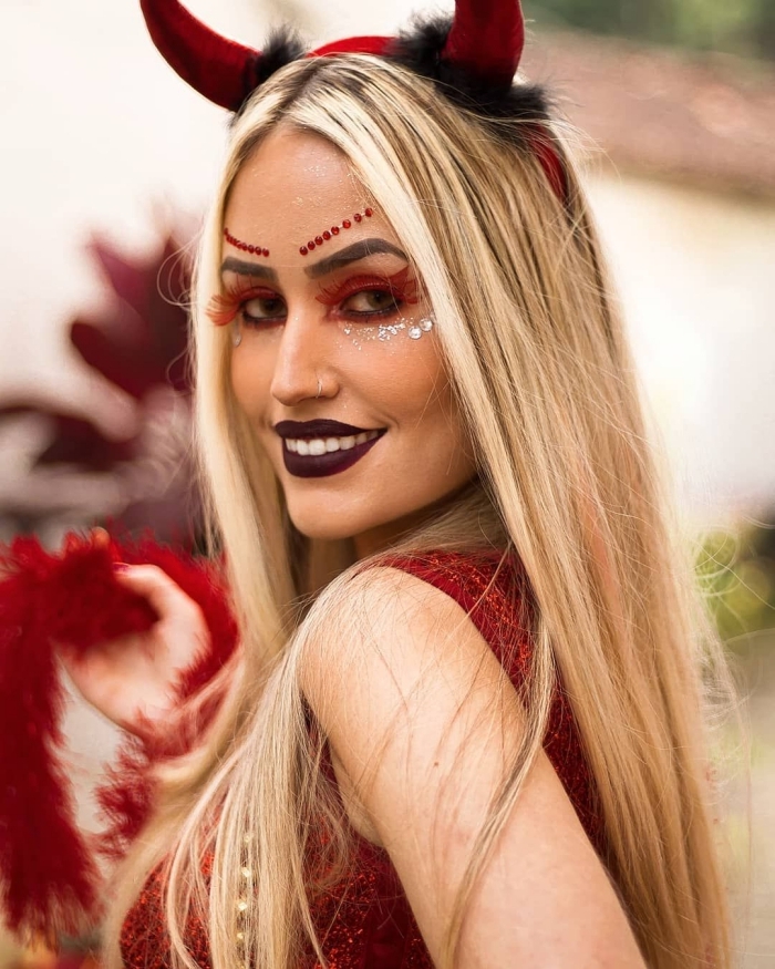 maquillage de diablesse original et fantaisiste inspiré des looks de festival avec des paillettes et des faux cils rouges