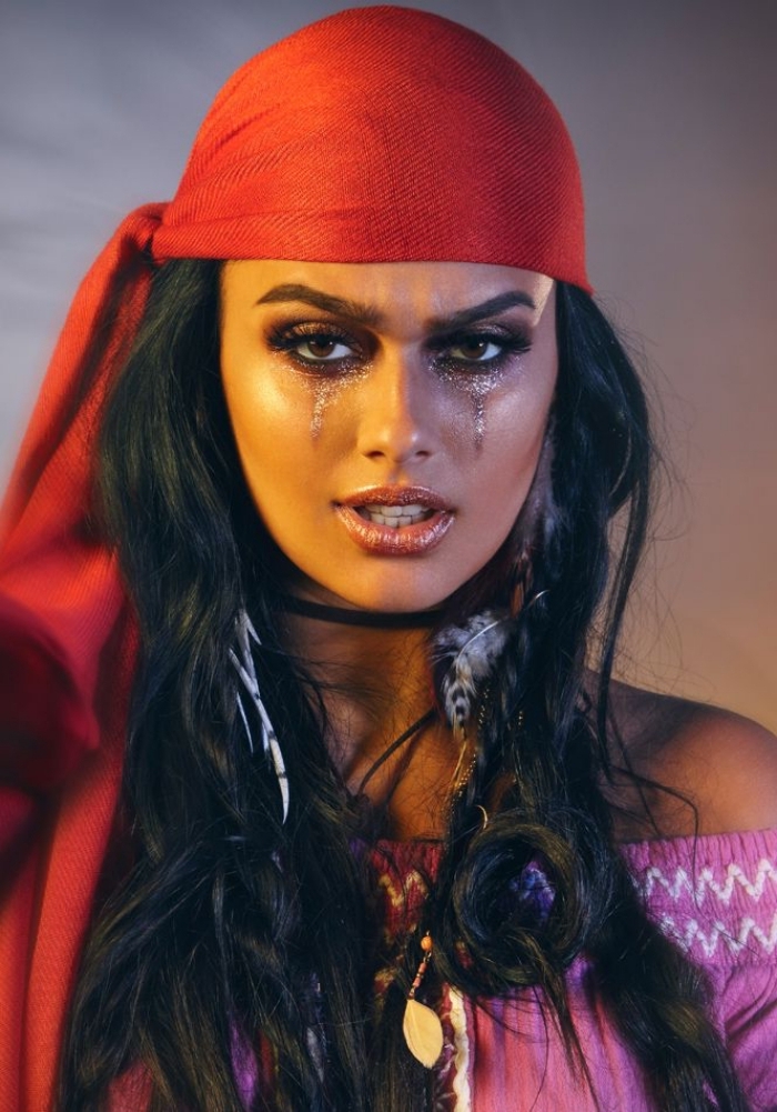 un joli maquillage femme pirate dans les tons bronze avec des yeux charbonneux, femme pirate sauvage avec un foulard rouge