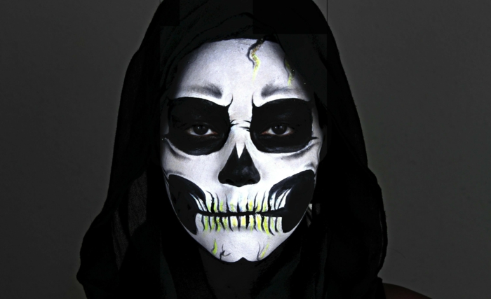 tete de squelette halloween, joues noires, creux des yeux noirs, visage peint blanc