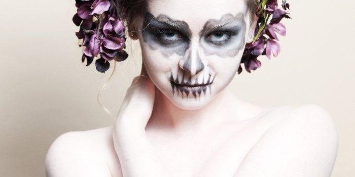 maquillage d'halloween à la fois glamour et macabre de tête de mort mexicaine au teint blafard et au vsiage peint