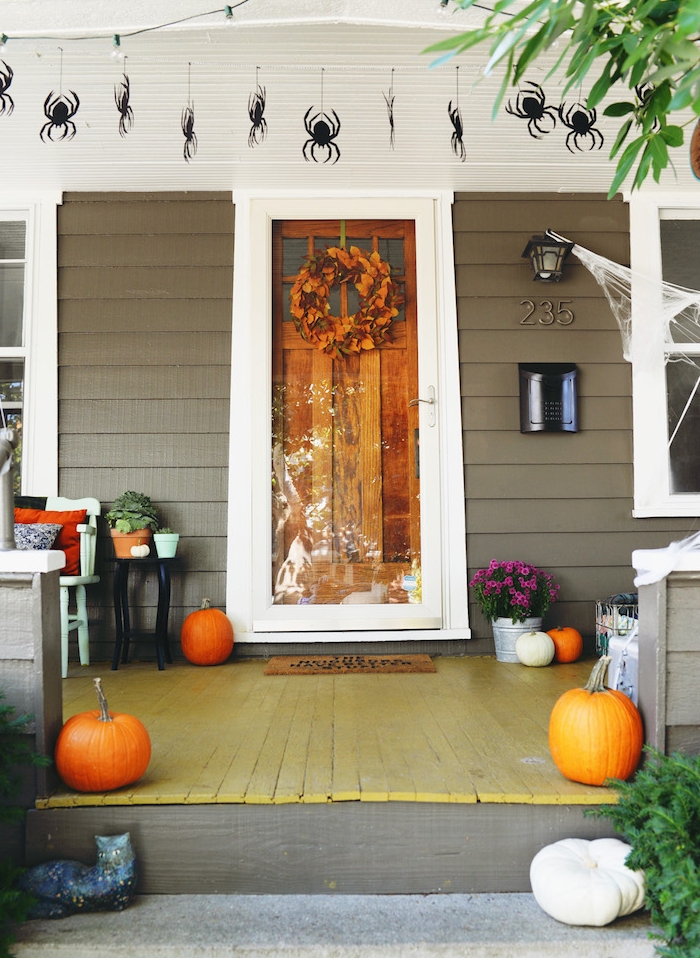 décoration halloween extérieur a fabriquer en citrouilles, couronne de feuilles mortes et des araignées suspendus en papier