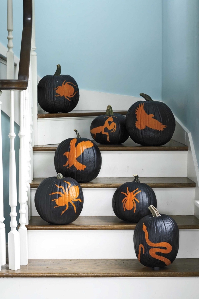 idée comment décorer un escalier intérieur pour la fête d'Halloween avec citrouille peinte en noir à déco dessins effrayants