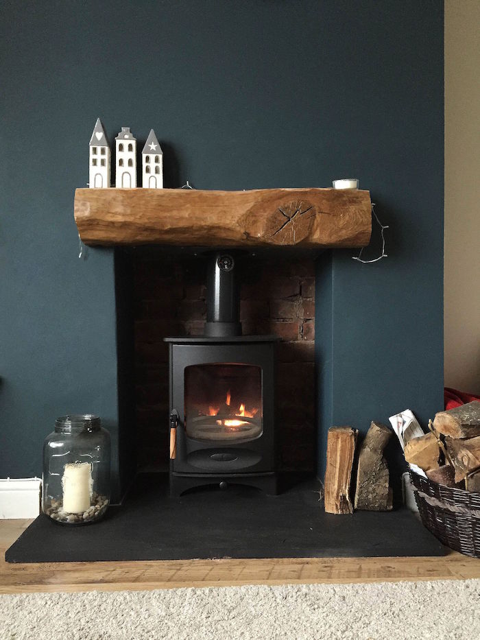 rénover et relooker une cheminée avec poele à bois, mur couleur bleu paon et étagère en bois et déco minimaliste