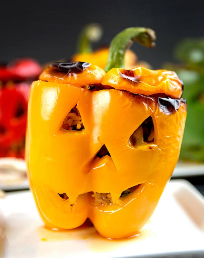 des poivrons farcis d'halloween découpés comme des citrouilles effrayantes lanternes d'halloween à servir comme plat principal 