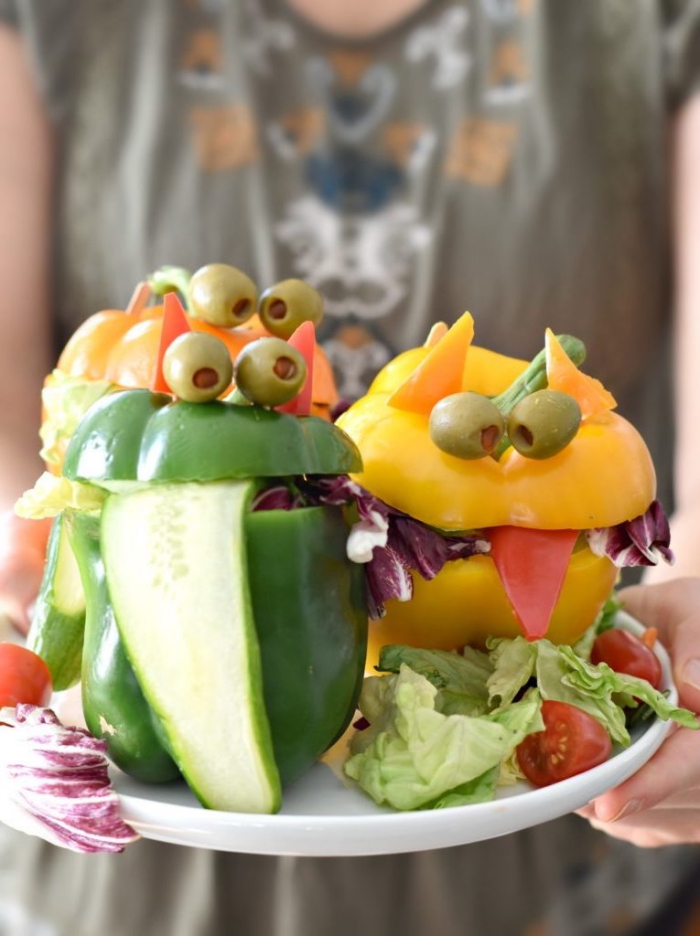 recette santé pour le repas halloween, des poivrons farcis de salade verte en forme de monstres d'halloween