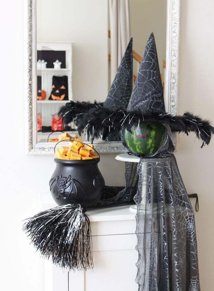 pot à feu noir et un pastèque transformé en sorcière avec chapeau sorcière et une cape sorcière, deco halloween maison