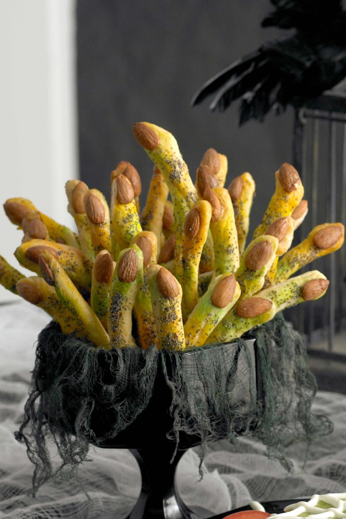 recette d'halloween effrayante de doigts de sorcière en bâtonnets de pain peints vert qui servent aussi de décor de table effrayant