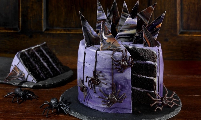 modèle de gâteau d halloween original en biscuits oréo et crème au beurre avec décoration à design morceau de chocolat marbré et figurines araignées en chocolat