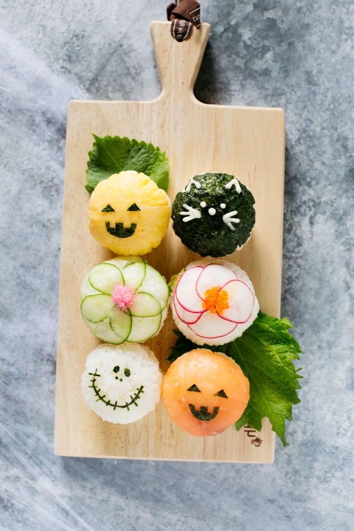 recette de temari sushi décoré pour la table d'halloween, boules de riz recouvertes de morceaux de saymon, algues, radis et concombre