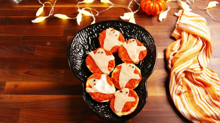 des mini-pizzas apéritives tomate et mozzarelle en forme de fantômes d'halloween, recette facile pour un apero dinatoire halloween à la fois effrayant et savoureux