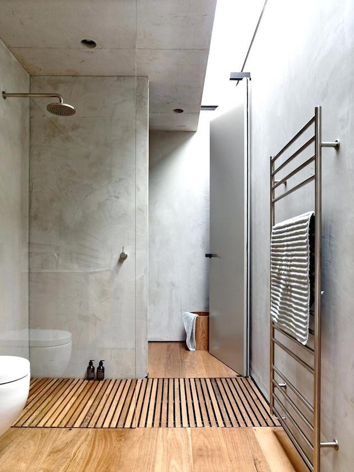 sans de bain moderne en béton ciré avec douche italienne sur sol en bois parquet