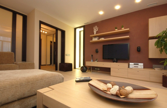 grande table en bois clair, peinture mur marron, étagères, meuble de tv, unités suspendues, grand sofa beige