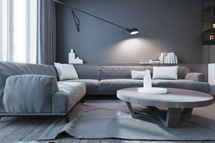 tapis gris dans un salon gris, sofa d'angle confortable et table de salon ronde