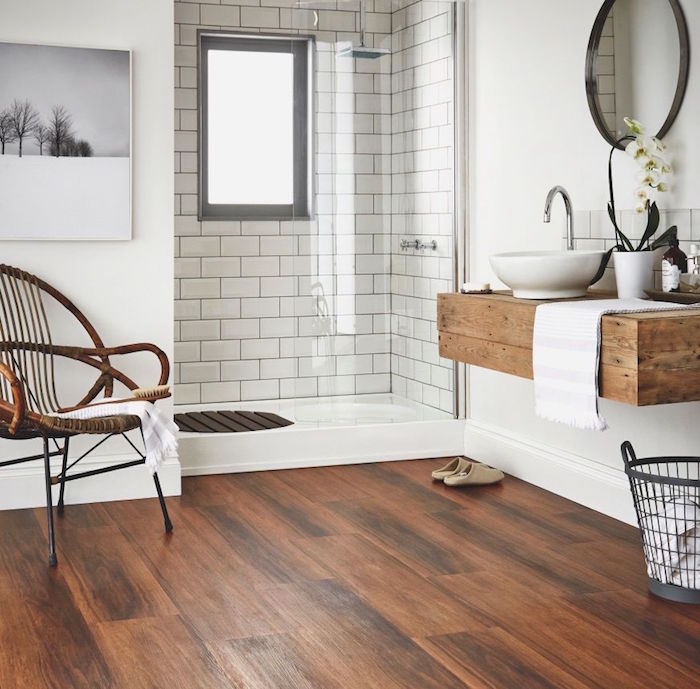 salle de bain sans carrelage avec parquet flottant et support lavabo en bois rustique, douche carrelée et murs blancs