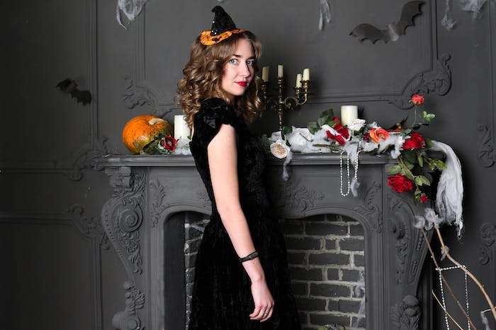 deguisement magicien, style sorcière avec une robe noire et un chapeau sorcière original en noi et orange, deco cheminée halloween