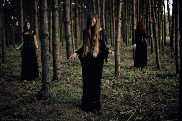 coven de sorcière vêtues en longues robes noires, look sorcière sans maquillage, sorcières dans la forêt, cadre naturel