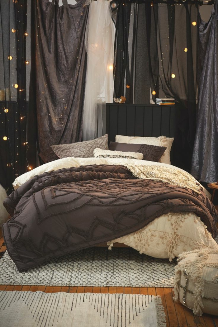 tapis tissés à plat, grand lit décoré de draps marron et crème, guirlandes lumineuses, tête de lit gris anthracite