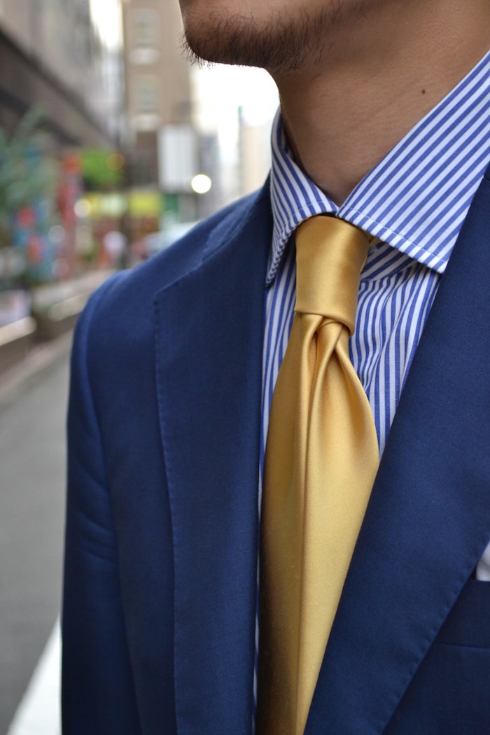 cravate en soir jaune or sur chemise avec noeud double windsor rayée bleu blanc et veste marine