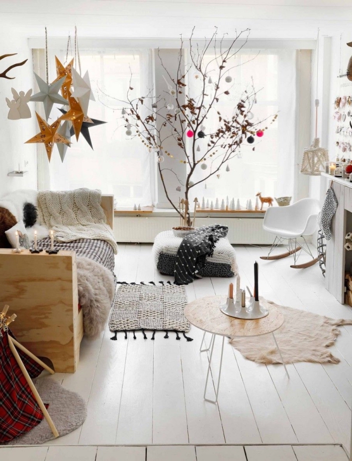 deco cocooning dans un salon blanc de style scandinave qui privilégie les matières et les textiles douillets et chauds, avec un beau arbre de noël décoré pour une touche naturelle dans l'intérieur
