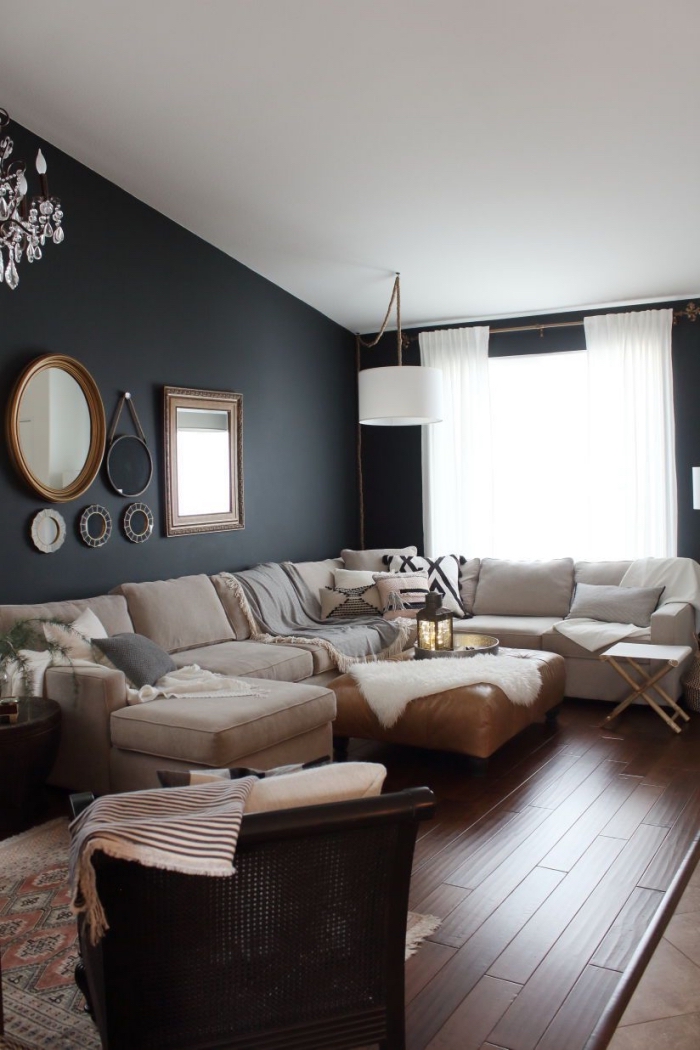 la tendance hygge deco scandinave pour un intérieur cocooning qui invite à la détente, salon blanc et noir avec des cadres déco vintage et un grand canapé d'angle accueillant