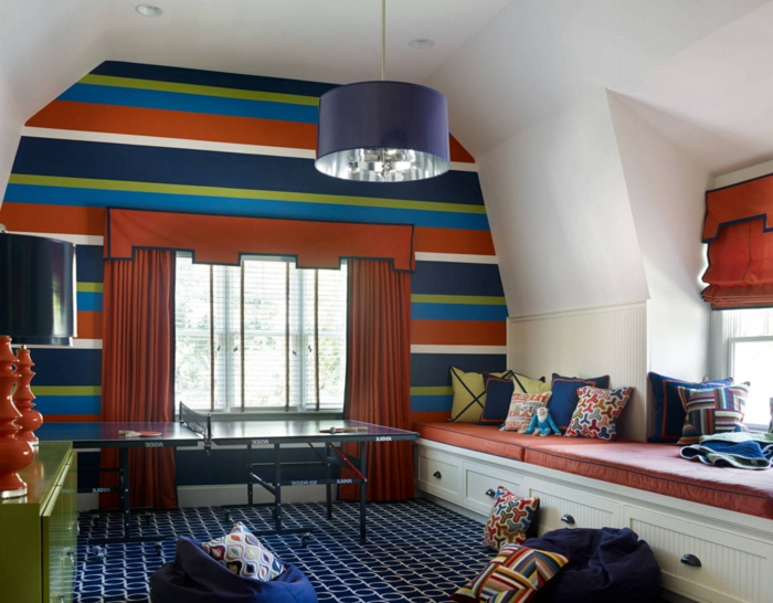 chambre de garçon en rouge et bleu, tapis géométrique, rideaux rouges, alcôve avec lit, plafonnier bleu