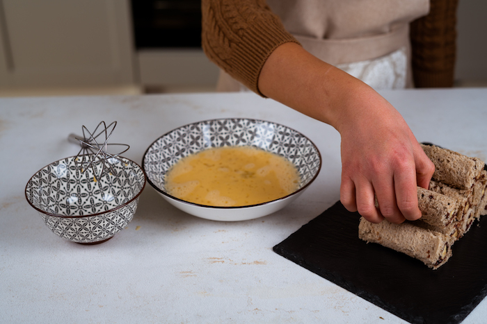 faire tremper les roulés de pain de mie dans mélange d oeufs, lait et sucre glace avant de faire frire, comment faire du pain perdu recette originale