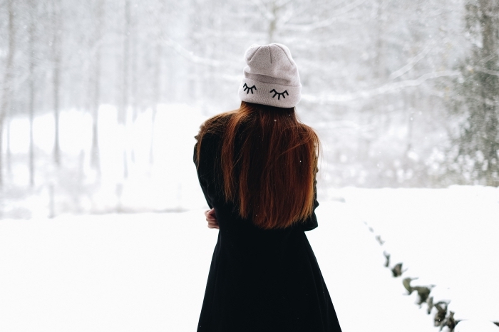 idée image de noel gratuite a telecharger, photo de jeune fille habillée en vêtements chauds pour hiver devant un paysage hiver