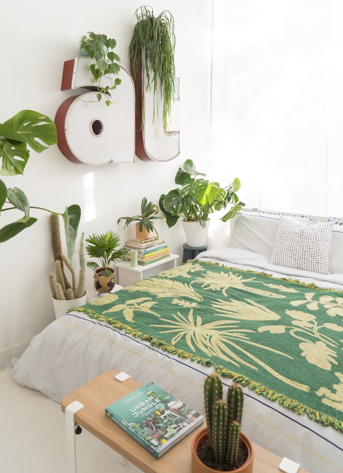 deco chambre adulte moderne en linge de lit blanc, et couverture de lit verte, deco lettres blanches avec accents verts et autres pots de fleurs avec plantes exotiques