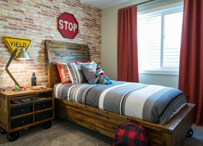 chambre de garçon style industriel, chevet sur roues, lit en bois, rideaux rouges, mur en briques
