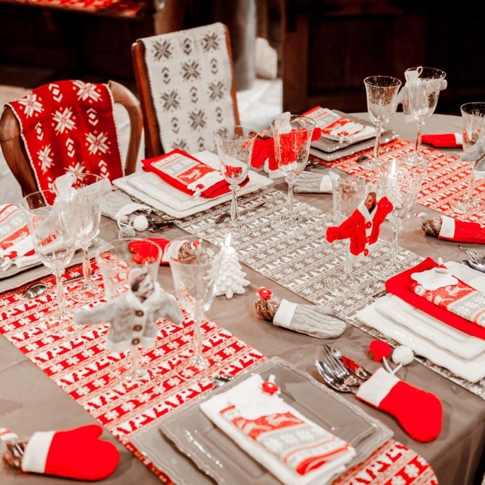 décorer une table de noel en blanc et rouge avec nappes et serviettes aux motifs flocons de neige et cerfs de noel, pliage serviette facile