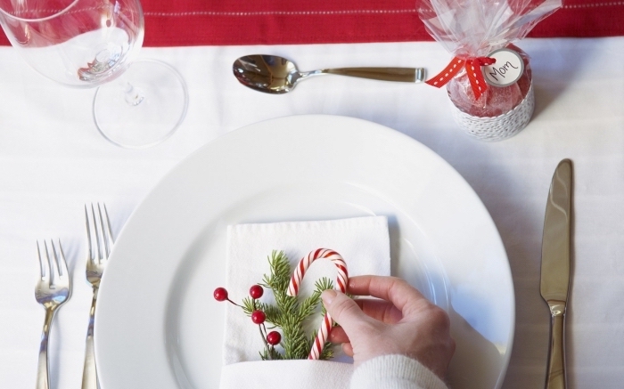 jolie décoration de table de Noel avec assiette blanche et serviette en tissu blanche, modèle pliage serviette facile pour noel