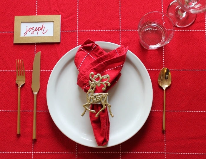 exemple de pliage serviette noel, déco table avec nappe rouge et serviette en tissu décorée de rond à serviette dorée