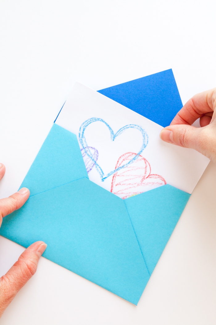 comment faire une enveloppe avec une feuille de papier carrée, à l'aide de quelques pliages, quelques coups de ciseaux et un peu de colle, pochette diy pour vos cartes de voeux personnalisées
