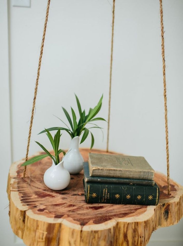 idée de table de nuit suspendue en rondin de bois suspendu à une corde, ranger ses livres de chevet plantes