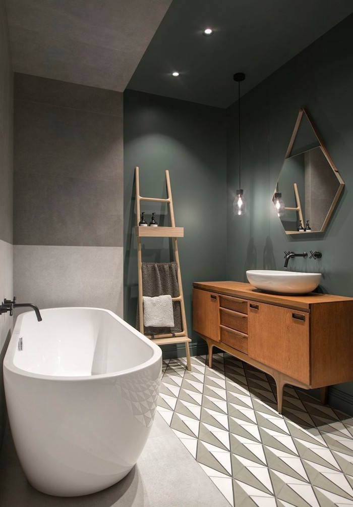 salle de bain scandinave avec meuble lavabo en bois retro sol en carrelage et ciment et murs bicolores vert de gris kaki et béton ciré avec baignoire design