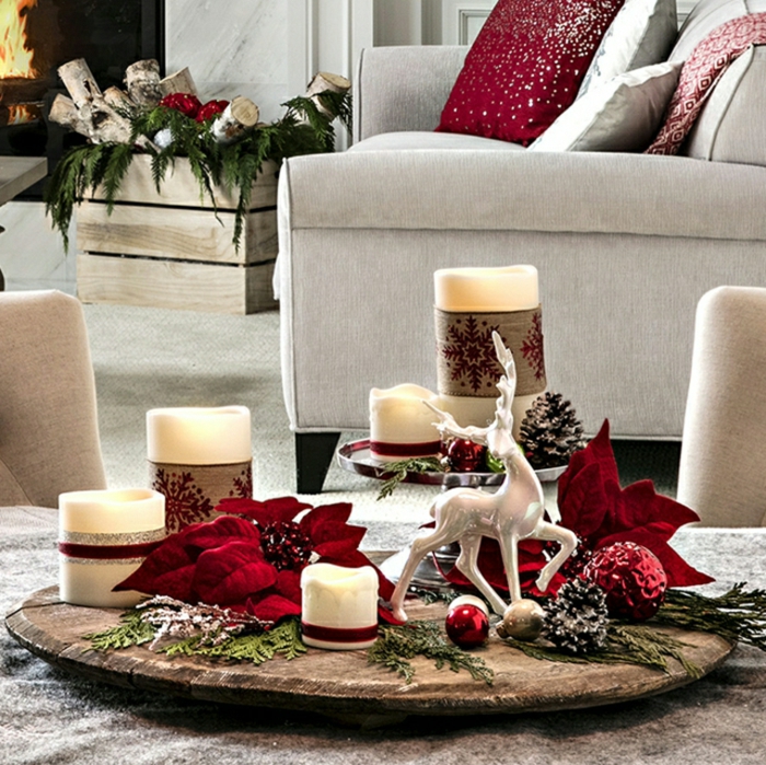 plateau en bois, deco table de noel, bougies blanches, feuilles rouges, chaises couleur beige, grand fauteuil gris